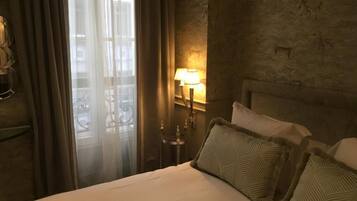 Ein Hotelzimmer mit einem Bett, Vorhängen, einer Lampe und einer Wand mit Tierreliefs.