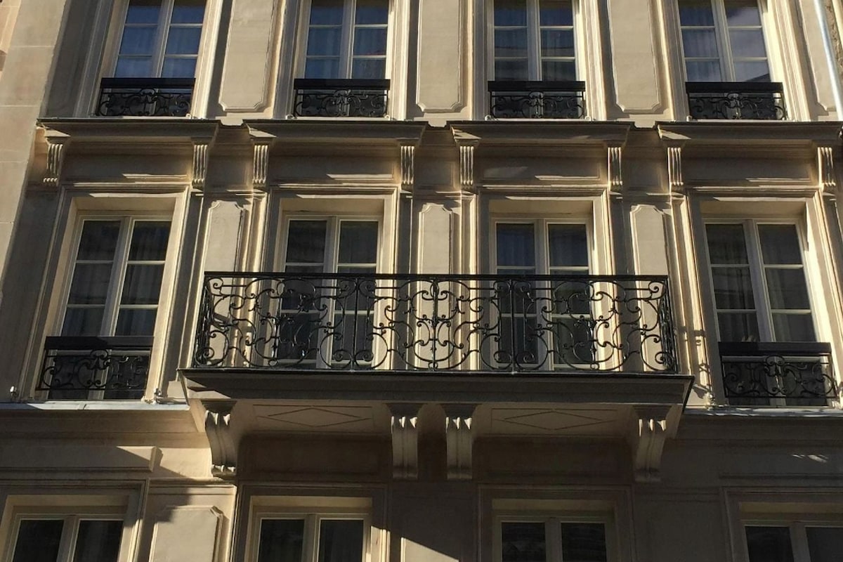 A multi-story building with a symmetrical facade, featuring evenly spaced windows and decorative moldings.