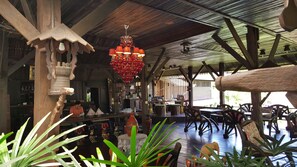 A rustic interior with wooden beams, a chandelier, and various decorative items. - Montania Lifestyle Hotel (Phanom)