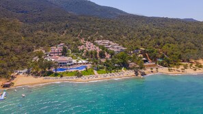 An aerial view of a coastal resort with multiple buildings, a swimming pool, and a beach. - Long Beach Club Nature (Didim)
