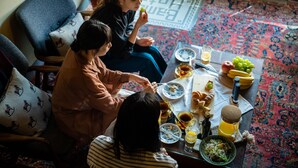A dining area with a table set for a meal, including plates, glasses, and a variety of food items.