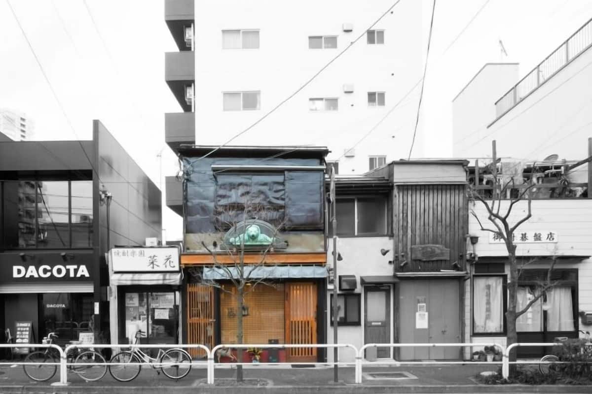 Vista da rua com um edifício identificado como 'DACOTA' e outro com uma placa '菊花'.