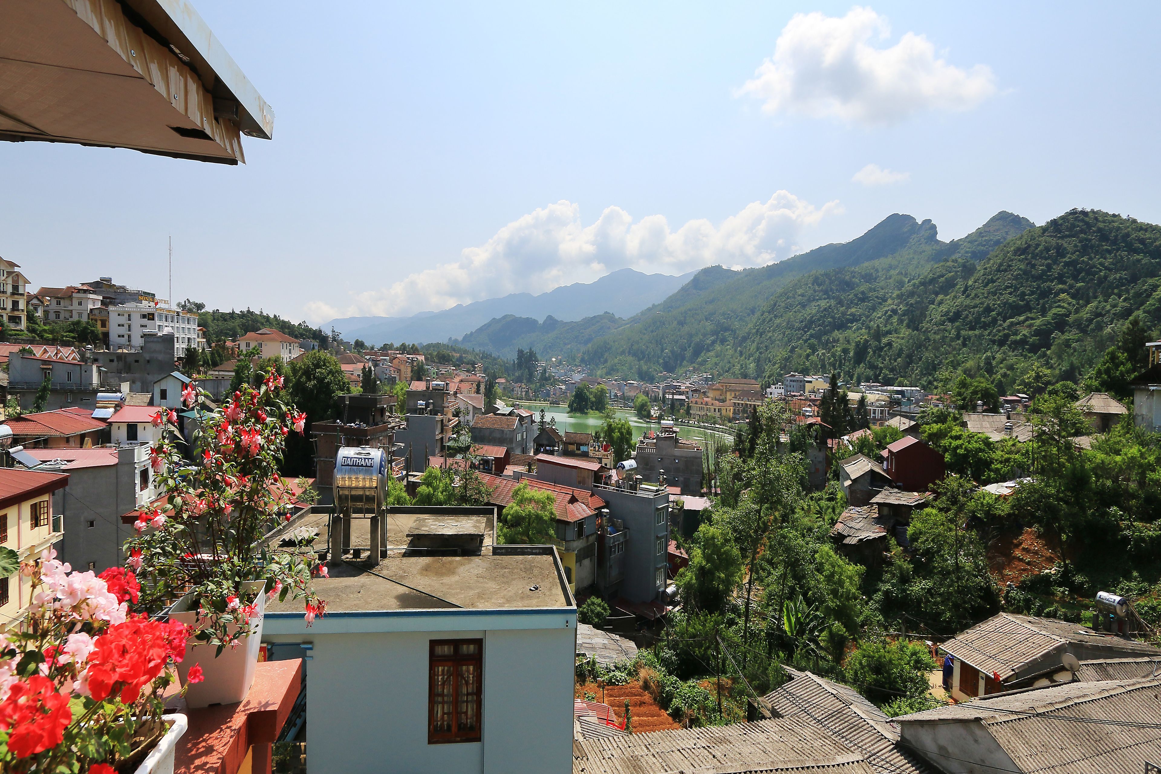 A residential area with houses, a river, and mountains in the background.