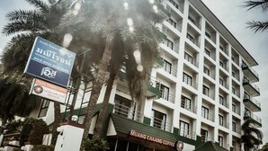 A multi-story hotel with a sign for 'Muang Chaang Coffee' at the ground level. - Maneerote Hotel Surin (Surin)
