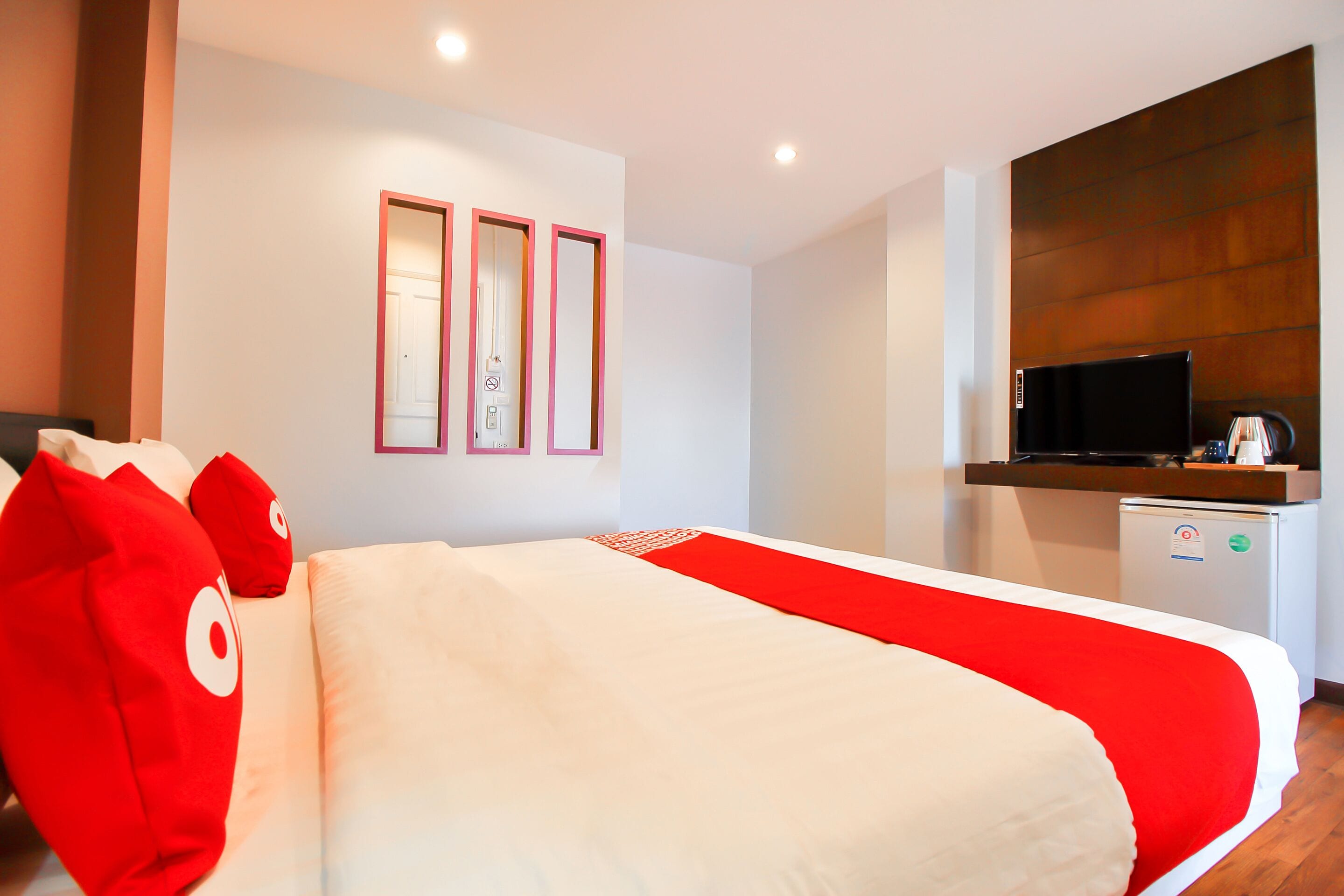 Een hotelkamer met een bed, een televisie en een kleine kitchenette.