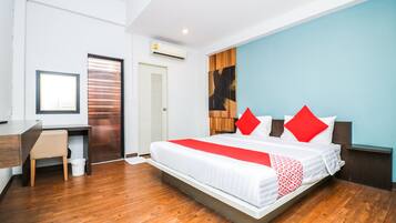 A modern hotel room with a large bed, a desk, and a chair.