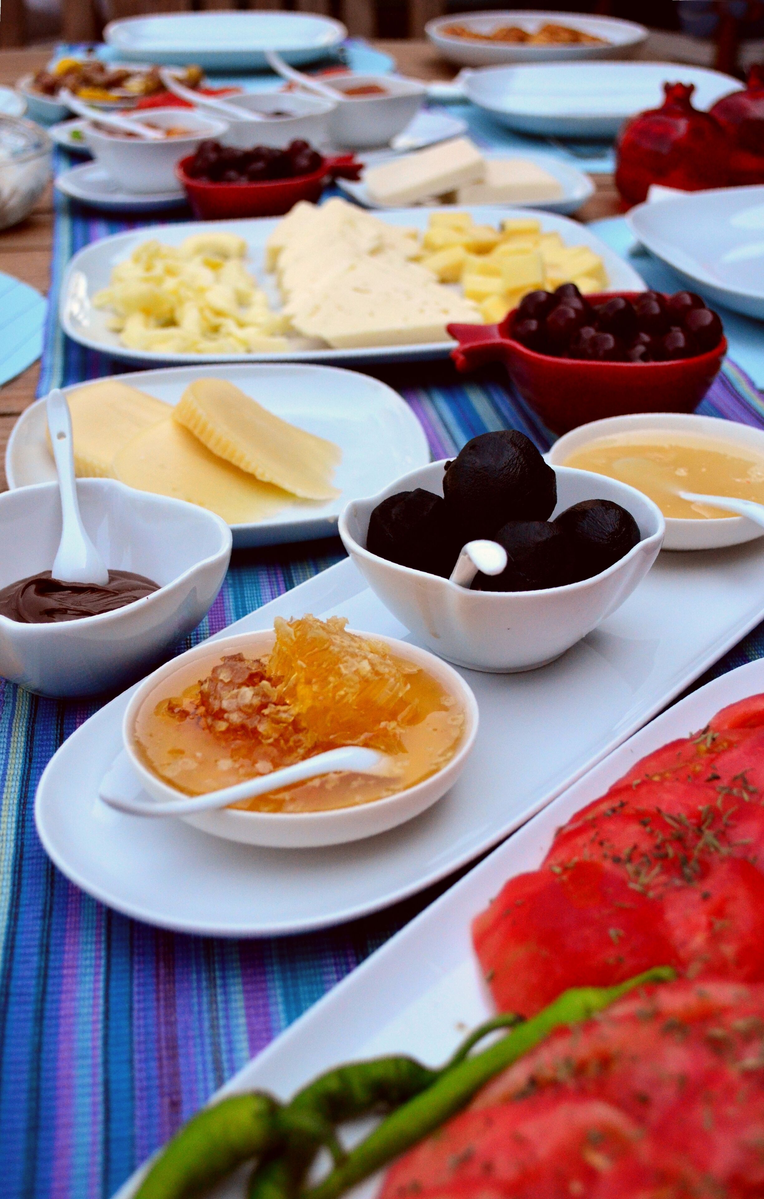 A table with various dishes and bowls of food, including what appears to be a pomegranate and a bowl of what might be a dessert or sauce.