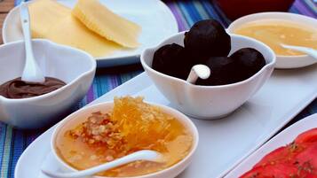 A table with various dishes and bowls of food, including what appears to be a pomegranate and a bowl of what might be a dessert or sauce.