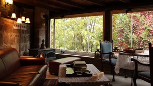 A cozy room with a fireplace, leather sofa, and a chessboard on a table. - Assos Nar Konak (Ayvacik)