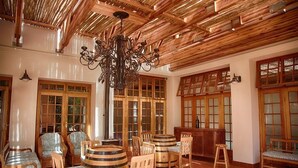A room with wooden furniture, a chandelier, and large windows. - Kleine Constantia (Roodepoort)
