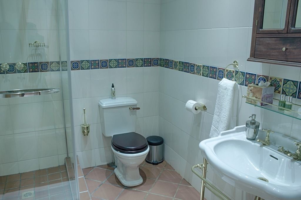 Un baño con inodoro, lavamanos y ducha.