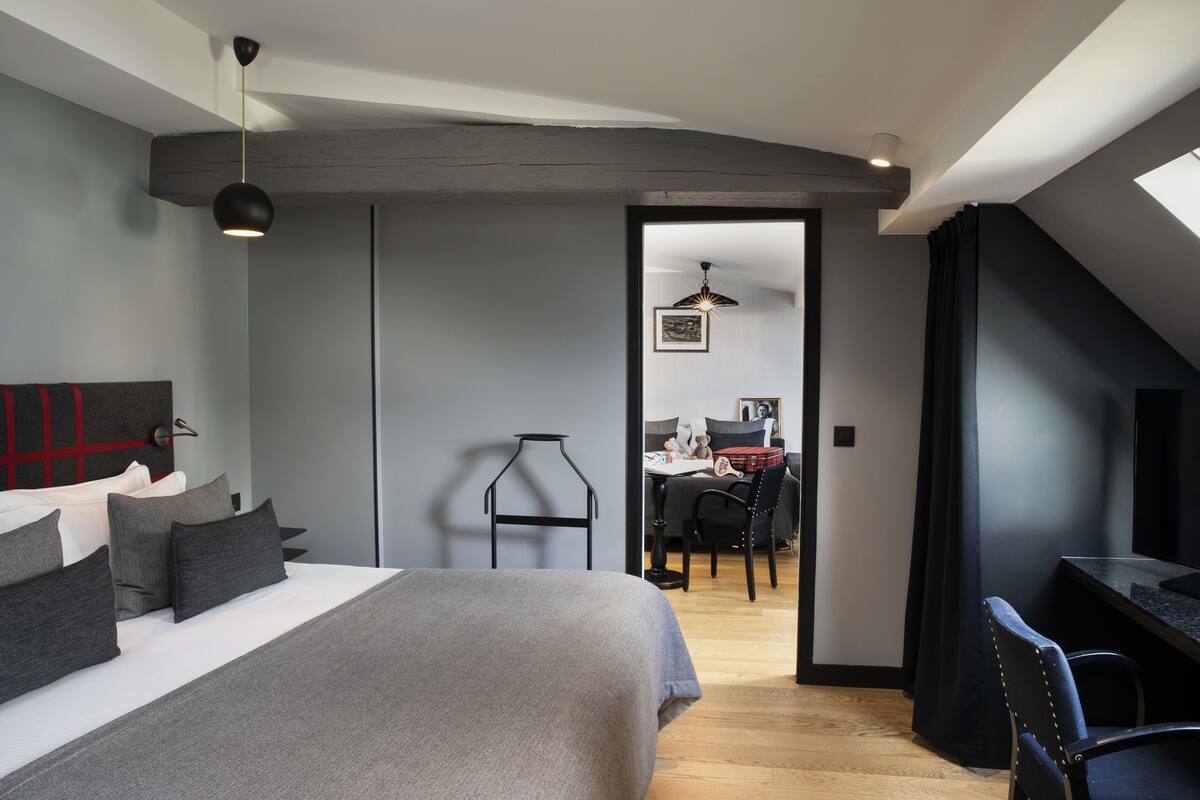 Un dormitorio moderno con una cama grande, un escritorio y un rincón comedor.