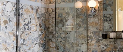 A bathroom with a glass-enclosed shower, a white bathtub, and a sink with a mirror above it.