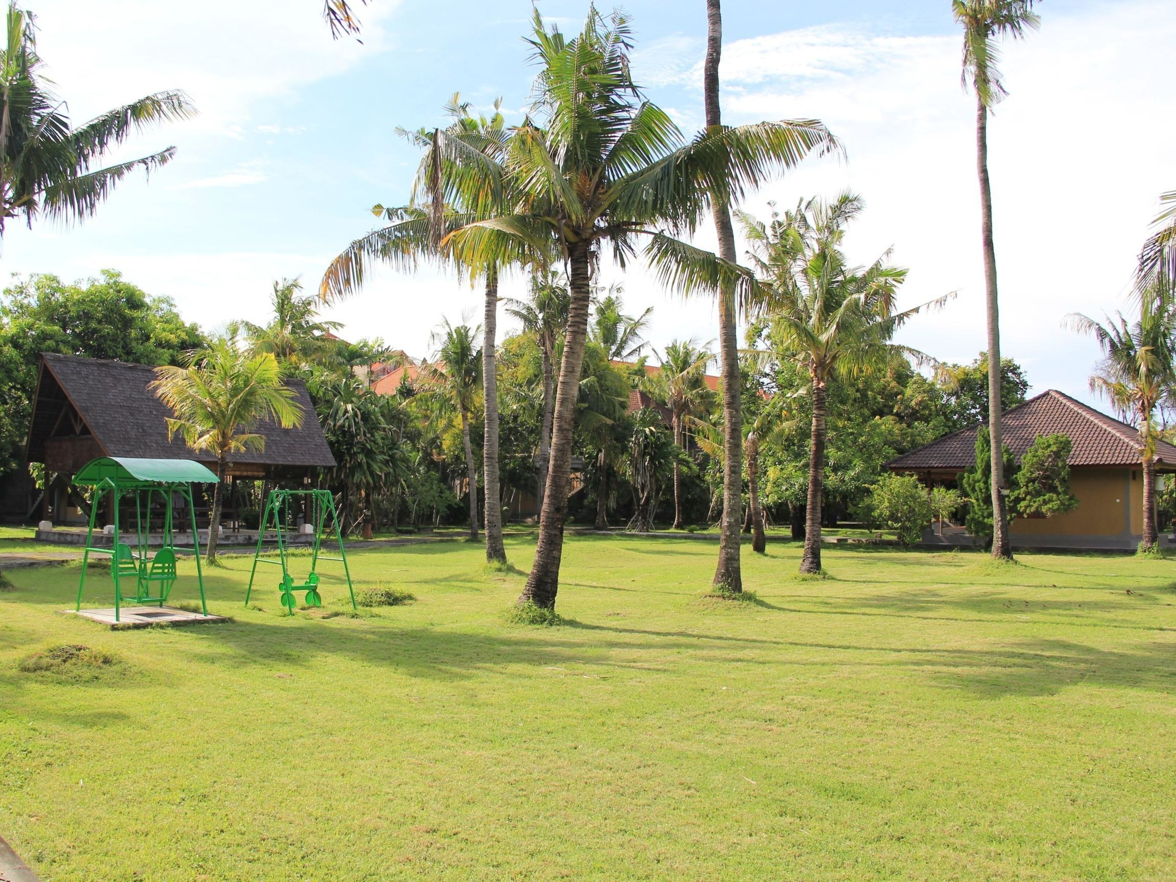 A grassy area with a swing set and a small pavilion.