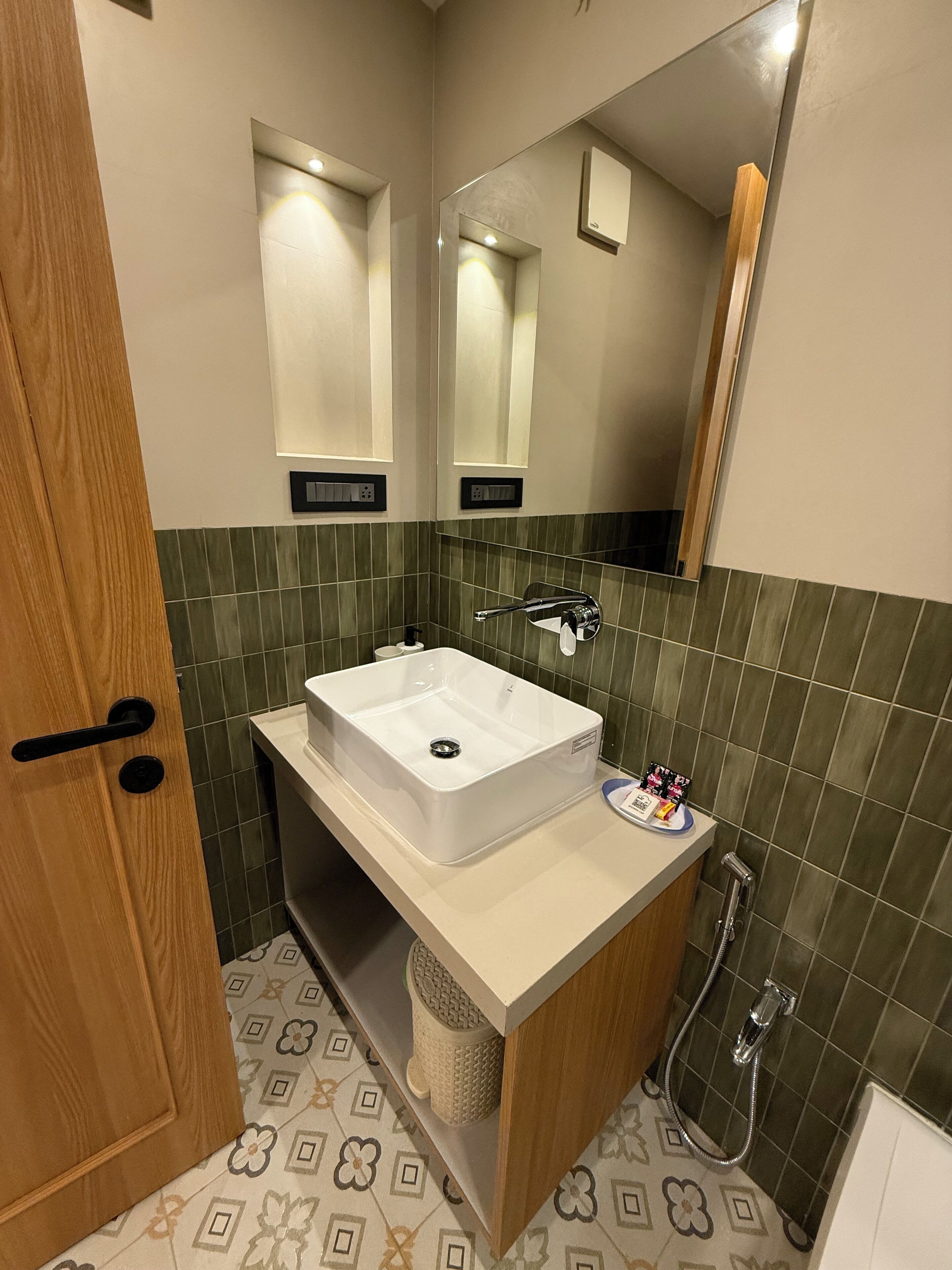 A modern bathroom with a white sink, a mirror, and a shower.