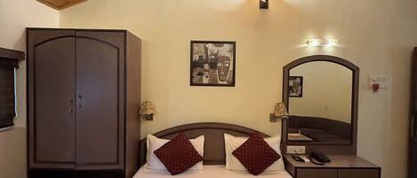 A bedroom with a bed, a wardrobe, a bedside table with a lamp, a mirror, and a ceiling fan.
