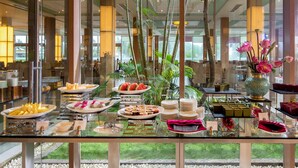 Zona de buffet amb diferents plats i una taula de vidre.