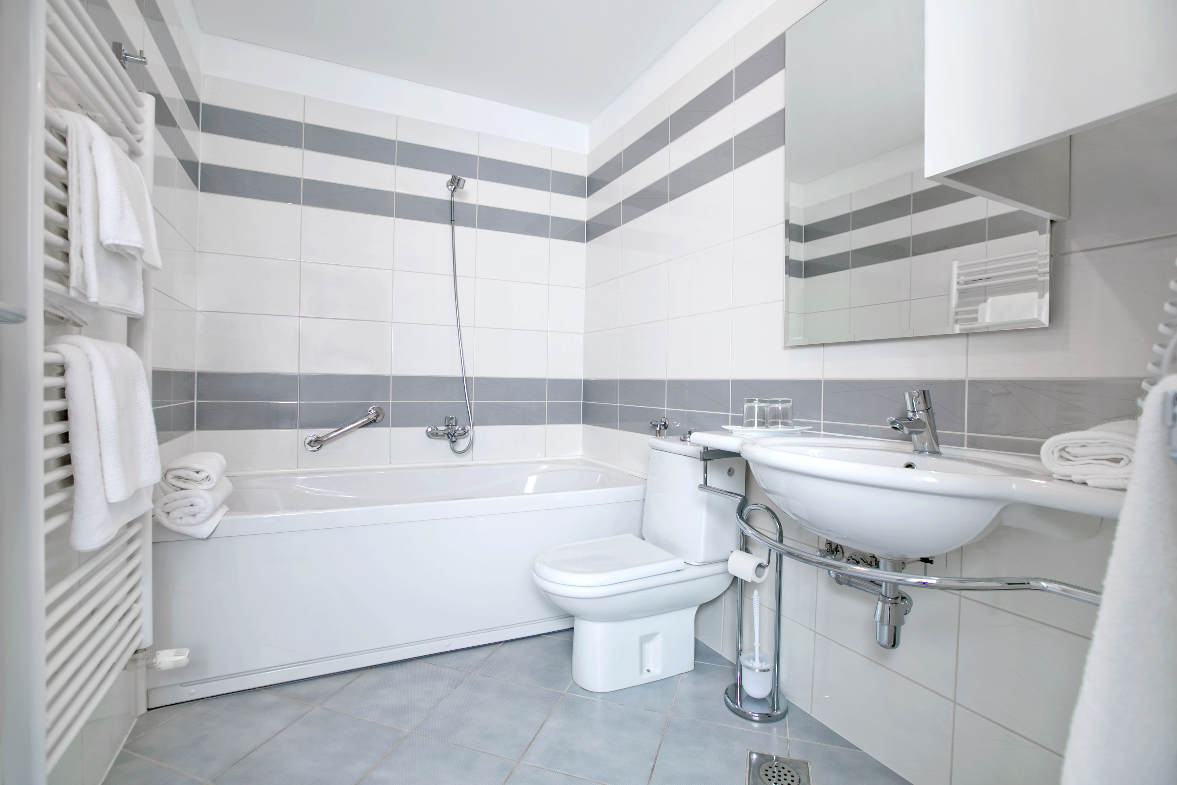 A modern bathroom with a bathtub, toilet, and sink.