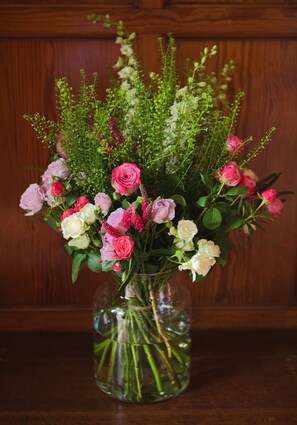 En blomstervase med blomster på et træbord.