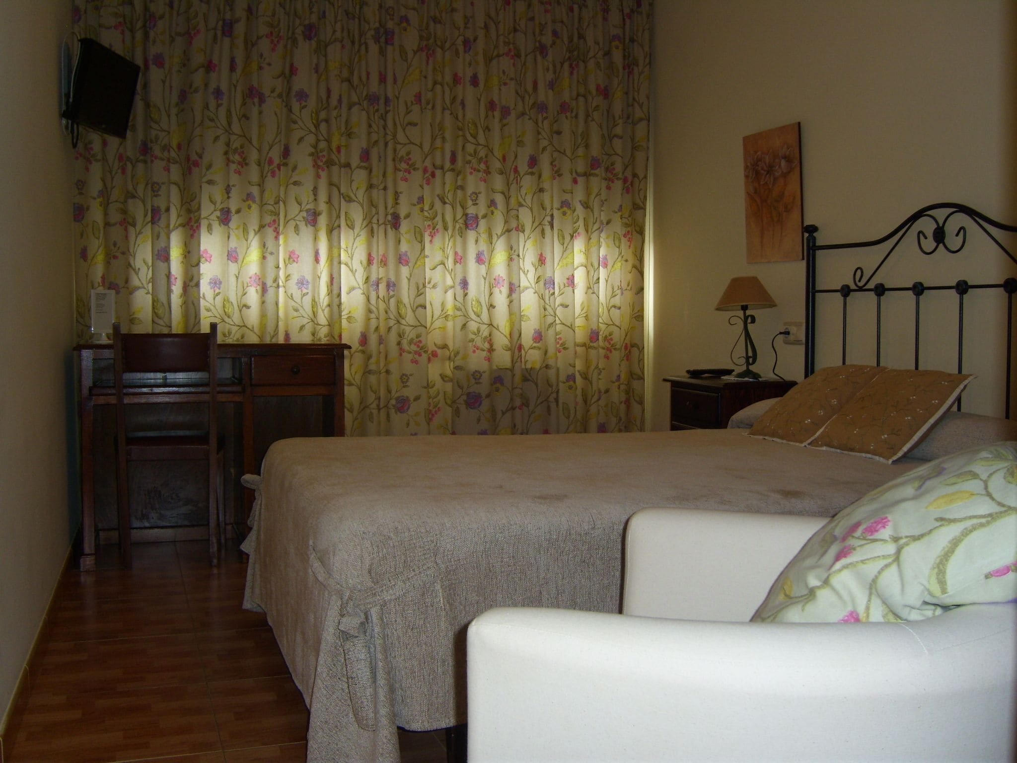 Un dormitorio con una cama, un escritorio y una silla.