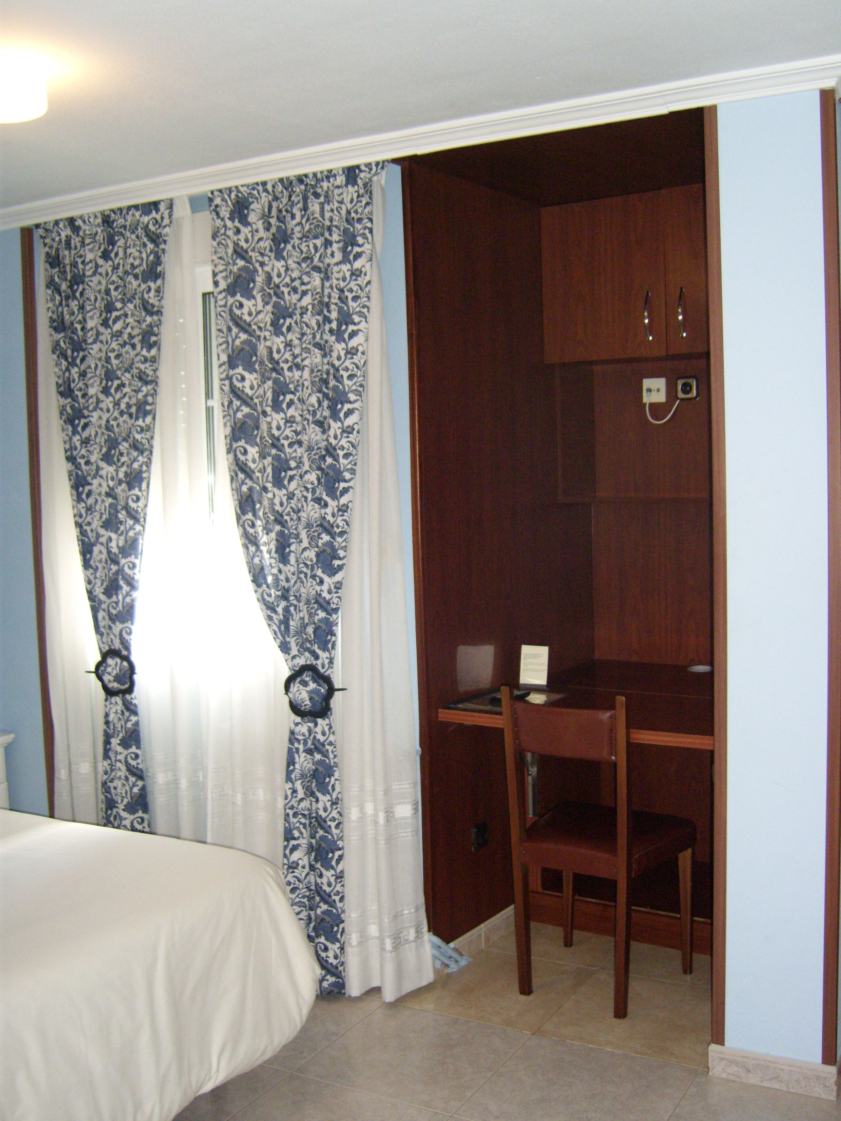 Ein Schlafzimmer mit einem Bett, einem Schreibtisch und einem Kleiderschrank.