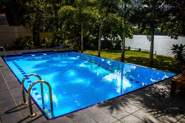 Outdoor pool, a waterfall pool, pool umbrellas, pool loungers