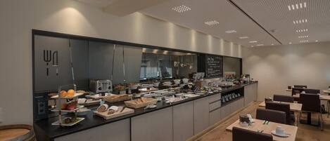 A buffet-style breakfast area with a variety of food items and a large mirror.