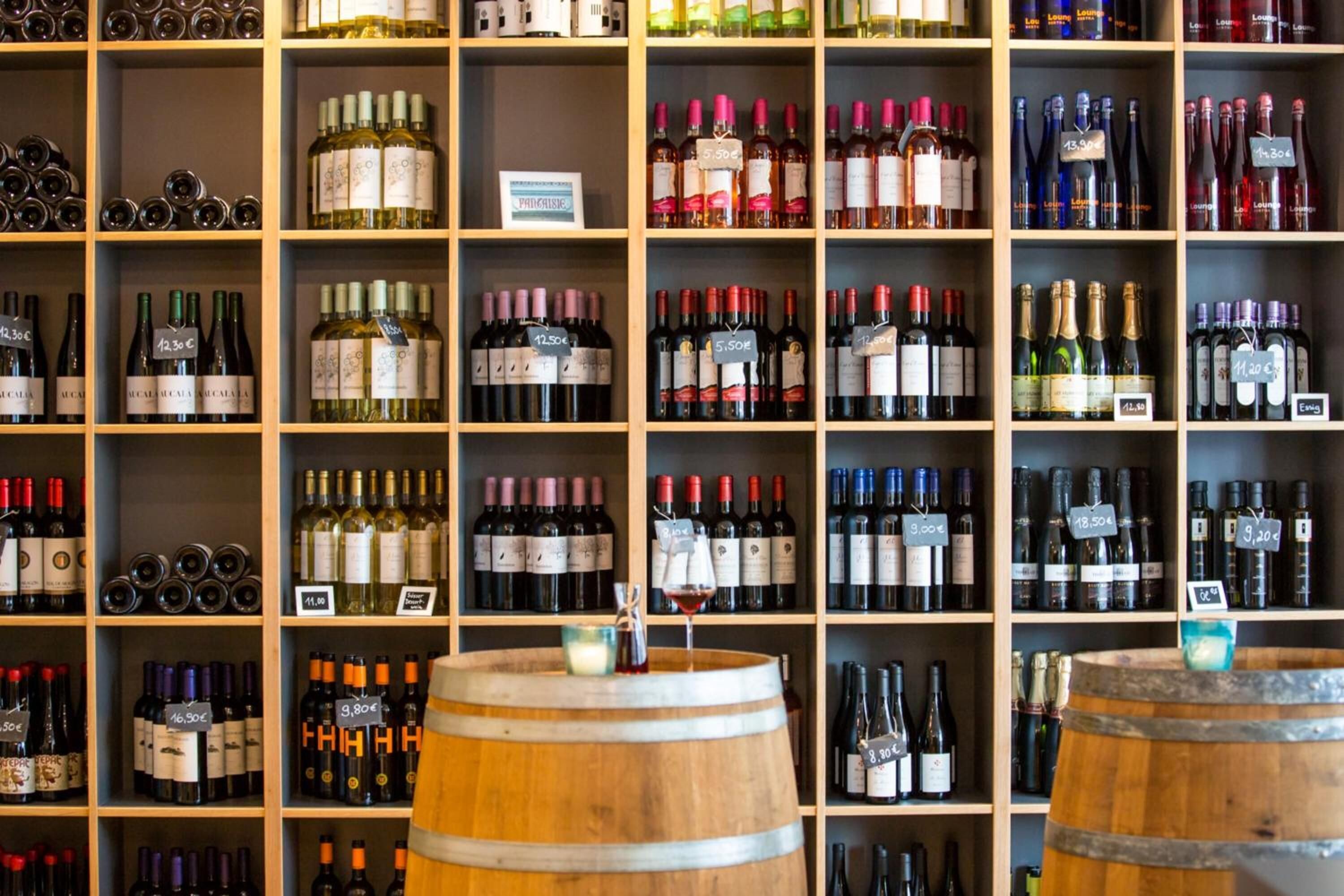 A wine cellar with shelves stocked with various bottles of wine, each labeled with a price tag.