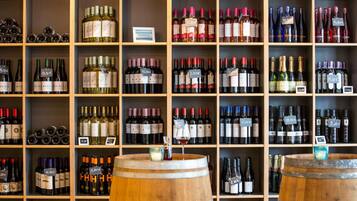 A wine cellar with shelves stocked with various bottles of wine, each labeled with a price tag.