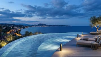 Een buitenzwembad, parasols voor strand/zwembad