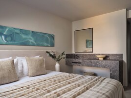 Una camera da letto moderna con un letto, un grande quadro astratto, una toeletta con uno specchio e una piccola pianta.