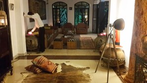 A room with a fireplace, wooden furniture, and a tripod with a light. - Accra Royal Castle Apartments & Suites (Kwabenya)