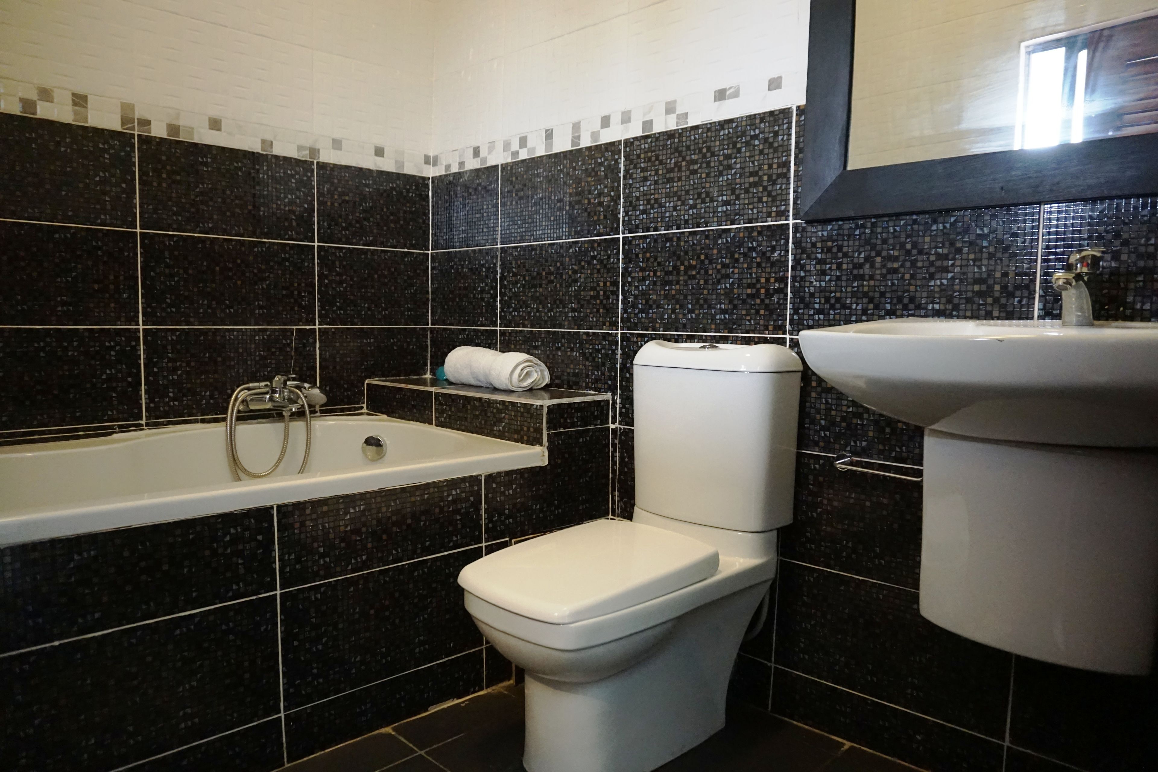 A bathroom with a bathtub, toilet, and sink.