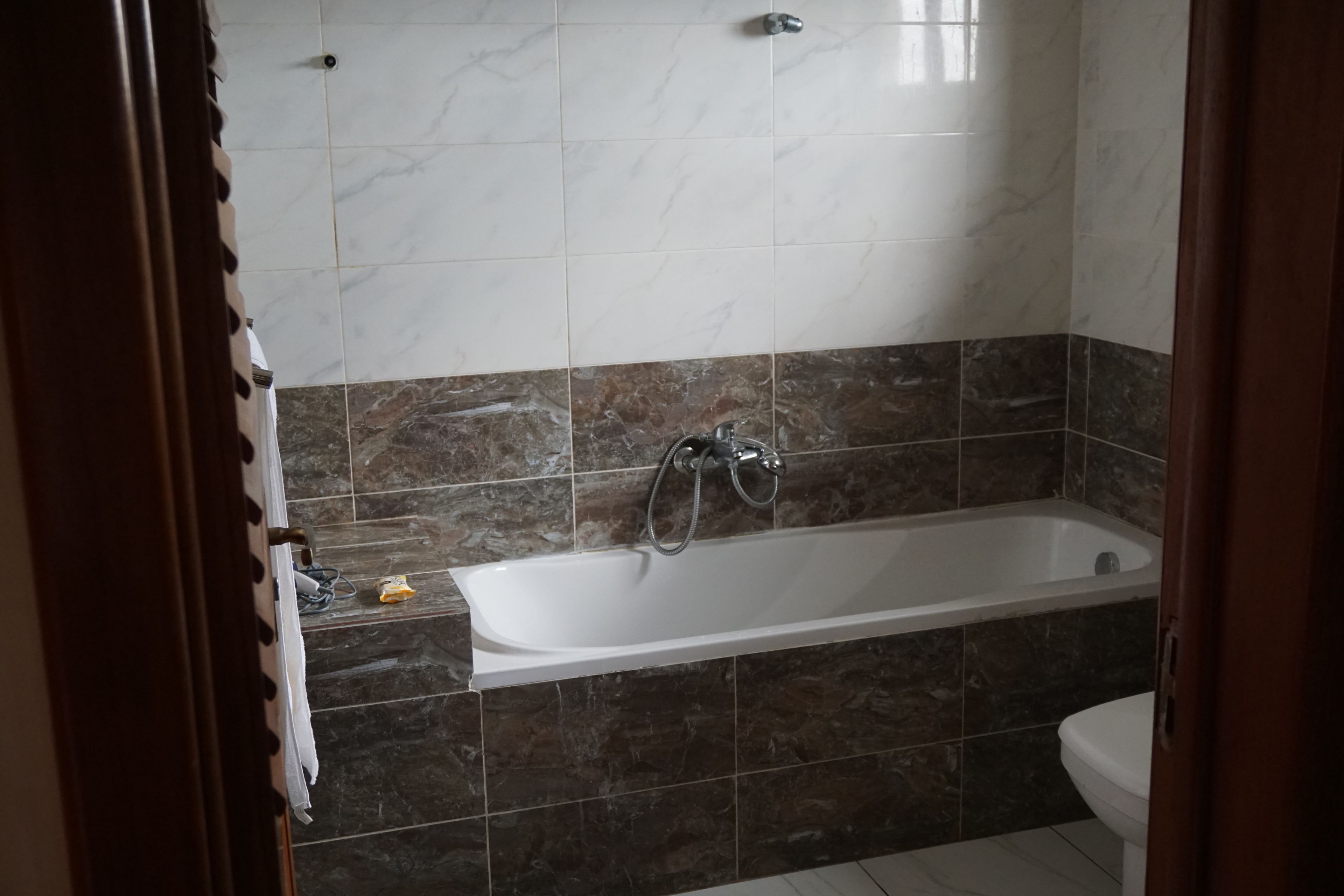 A bathroom with a bathtub, a toilet, and a shower area.
