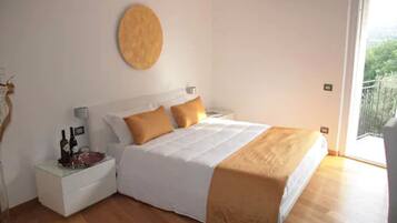 A bedroom with a bed, a nightstand, a round wall decoration, and a balcony view.