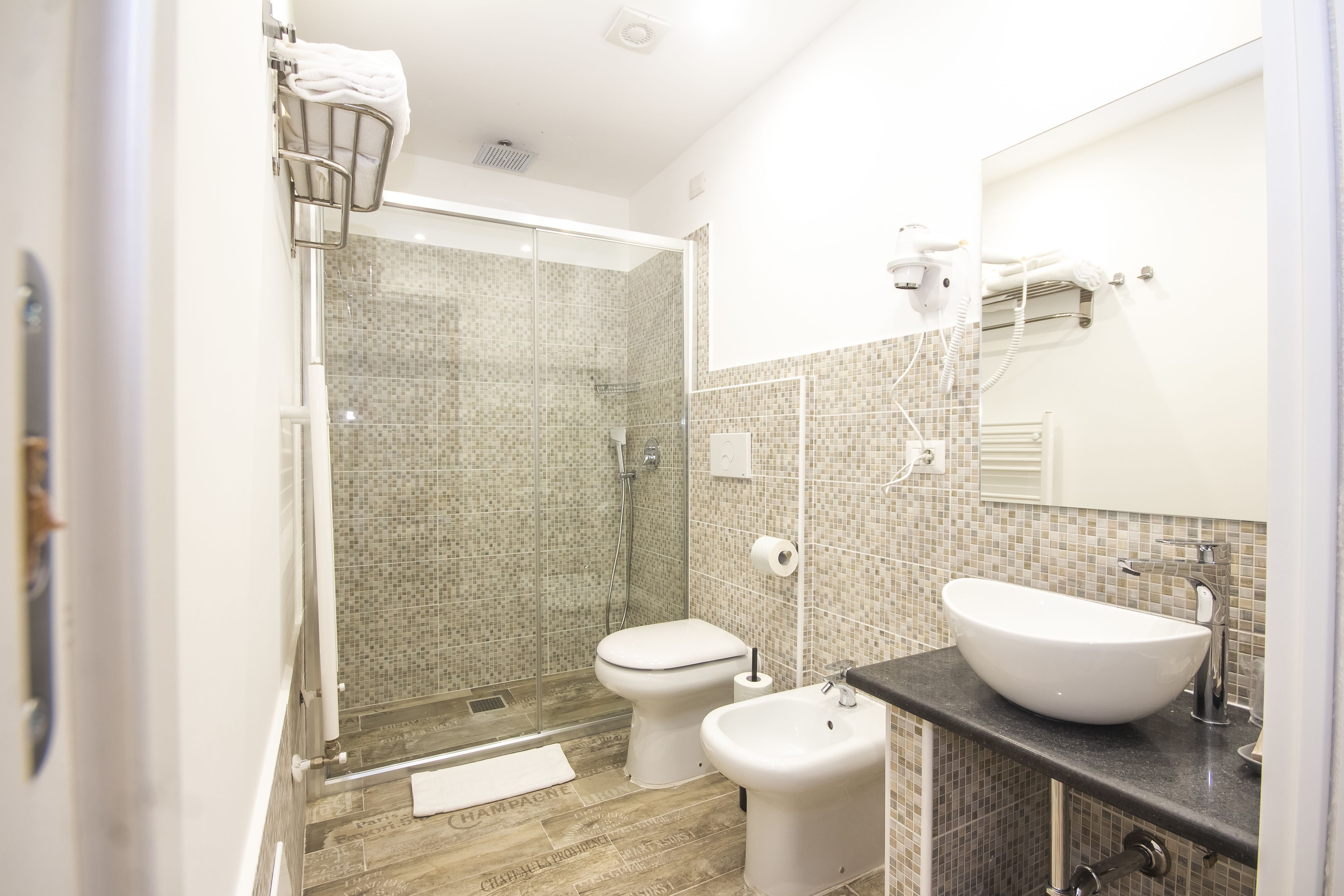 A modern bathroom with a glass-enclosed shower, a white toilet, and a large vessel sink.