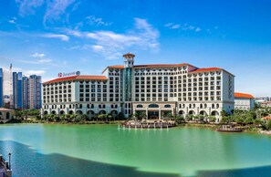 Un grande hotel con diversi piani, una torre centrale e vista sul lungomare.