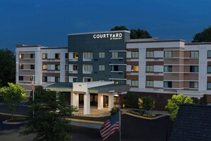 A multi-story hotel with a flat roof, a sign reading 'COURTYARD BY MARRIOTT,' and a parking lot with an American flag. - Courtyard Largo Medical Center Drive (Upper Marlboro)