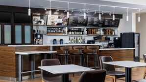 A modern bistro with a bar area, seating, and a menu display.