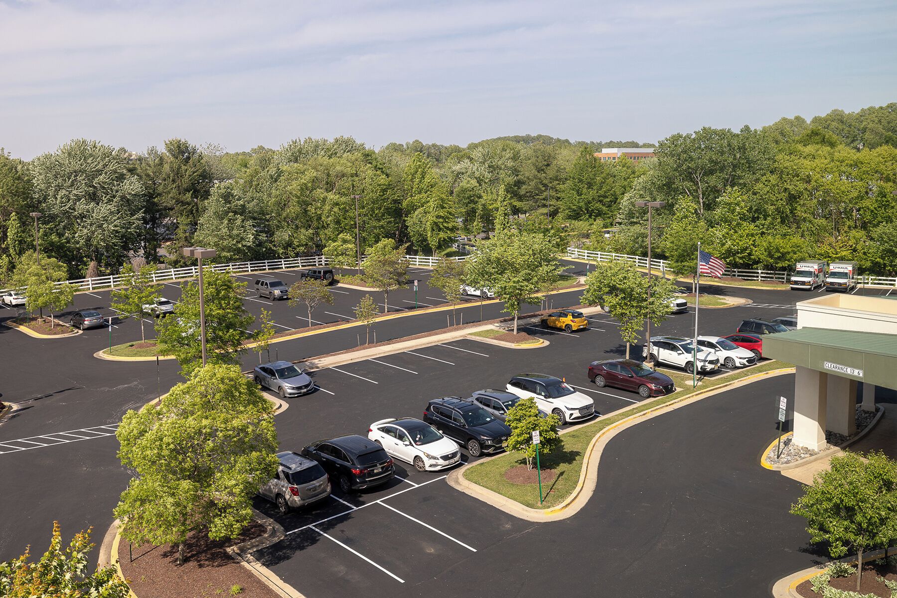 A parking lot with multiple cars and a building in the background.