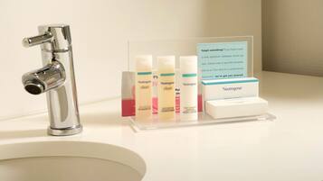 A bathroom sink with a chrome faucet and a clear display stand holding Neutrogena products.