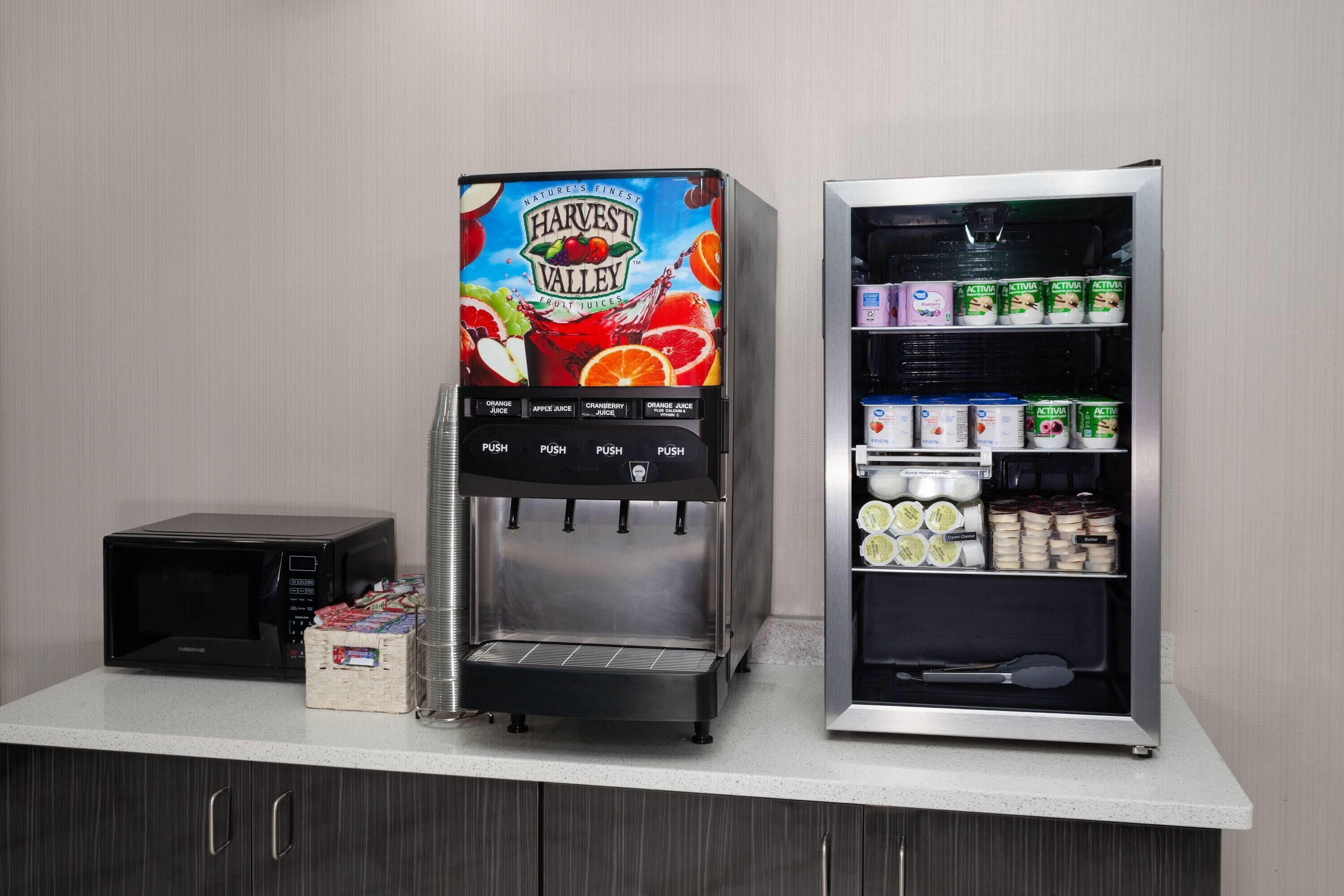 A beverage dispenser with multiple drink options and a refrigerated display case with various food items.