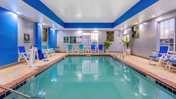 Een binnenzwembad en ligstoelen