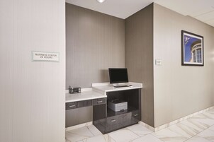 Centro de negocios con computadora, impresora y cajones para almacenamiento.
