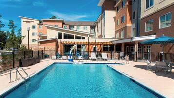Relax by the pool surrounded by lounge chairs and umbrellas.