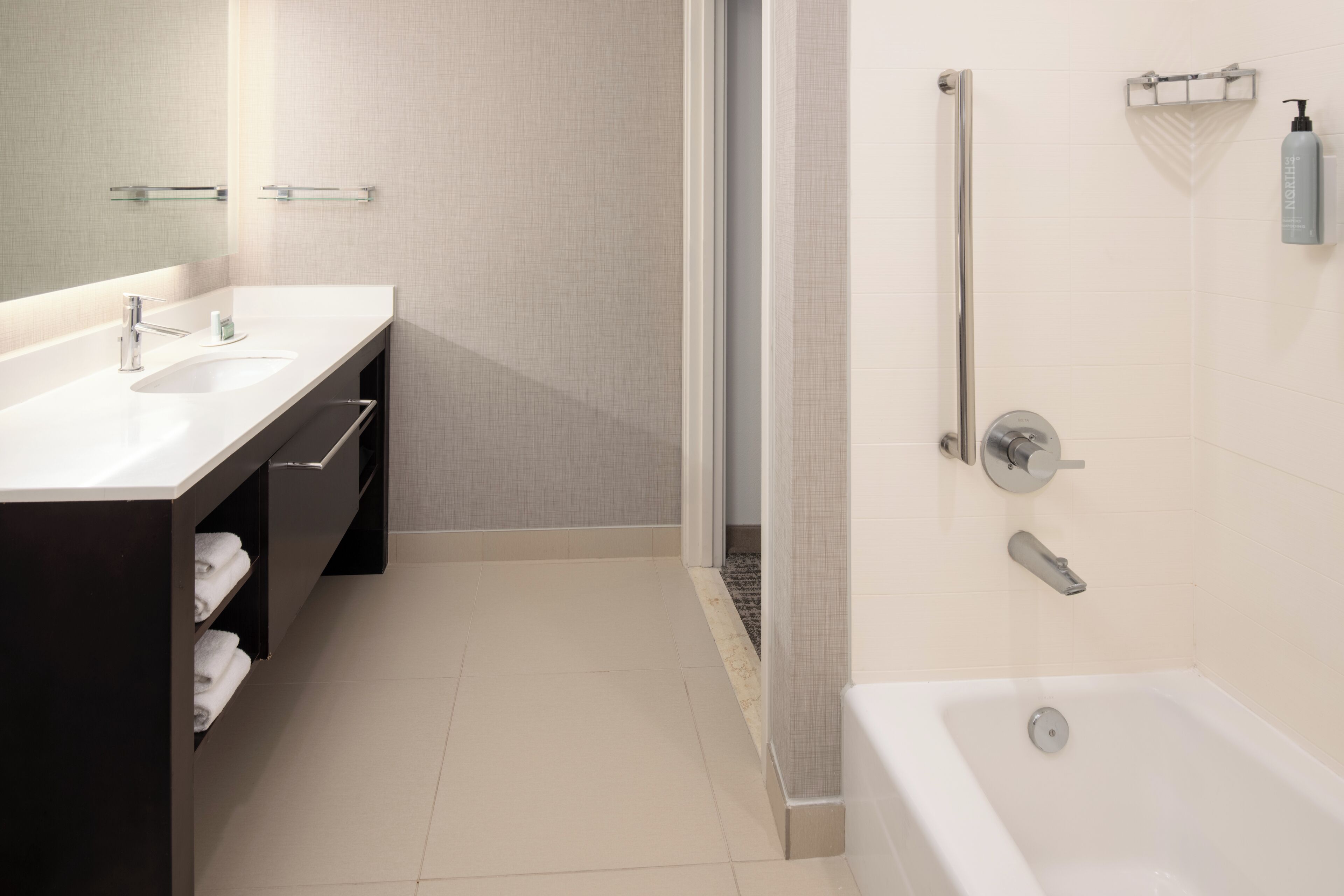 A modern bathroom with two sinks, a shower, and a bathtub.