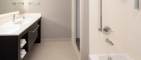 A modern bathroom with two sinks, a shower, and a bathtub.