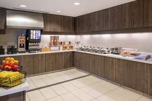 A modern kitchen with wooden cabinets, a coffee machine, a microwave, and a fruit display. - Residence Inn by Marriott Houston City Place (Spring)
