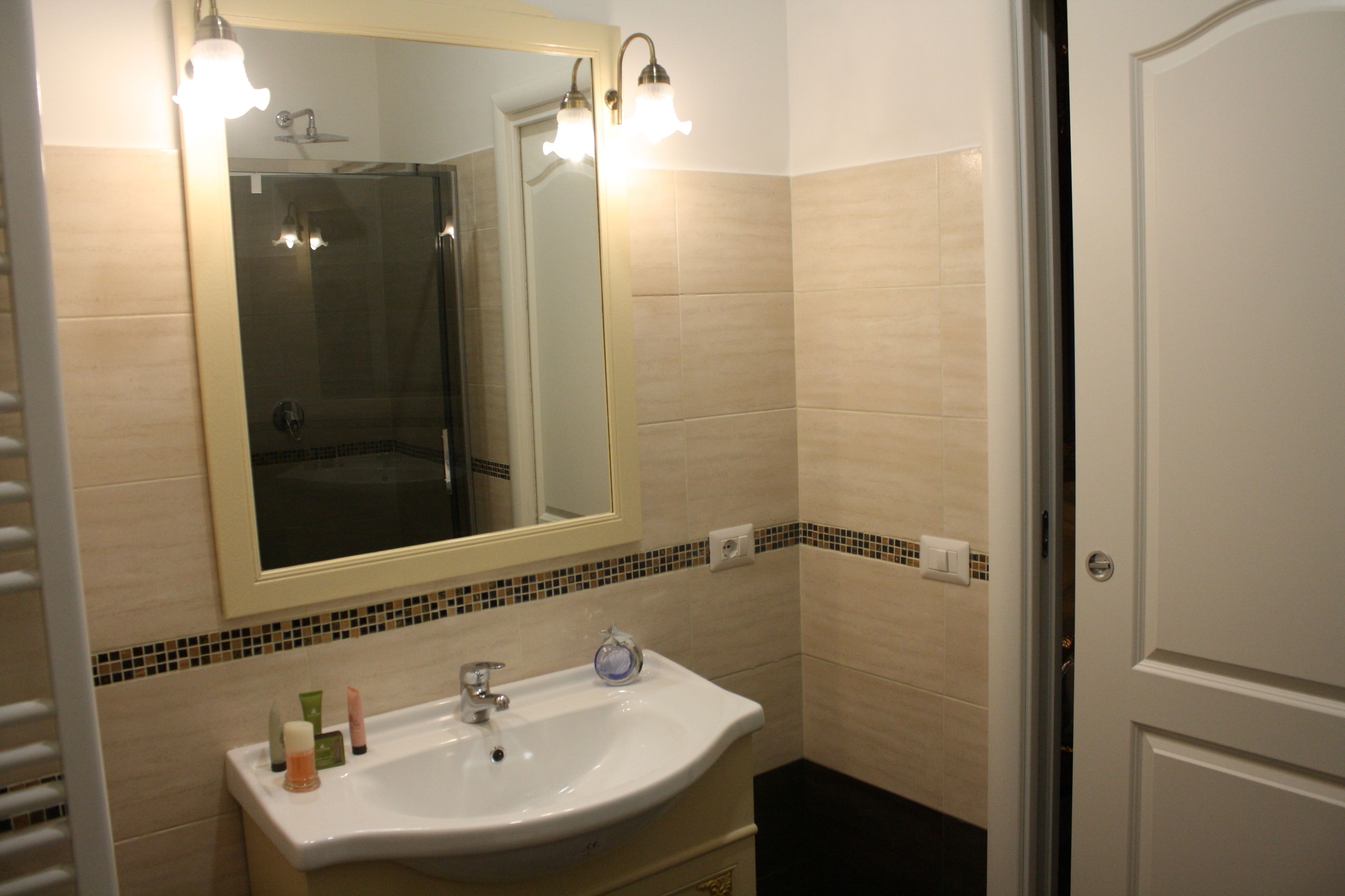 A bathroom with a white sink, a mirror, and a shower.