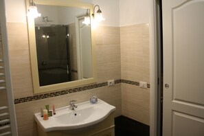 A bathroom with a white sink, a mirror, and a shower.